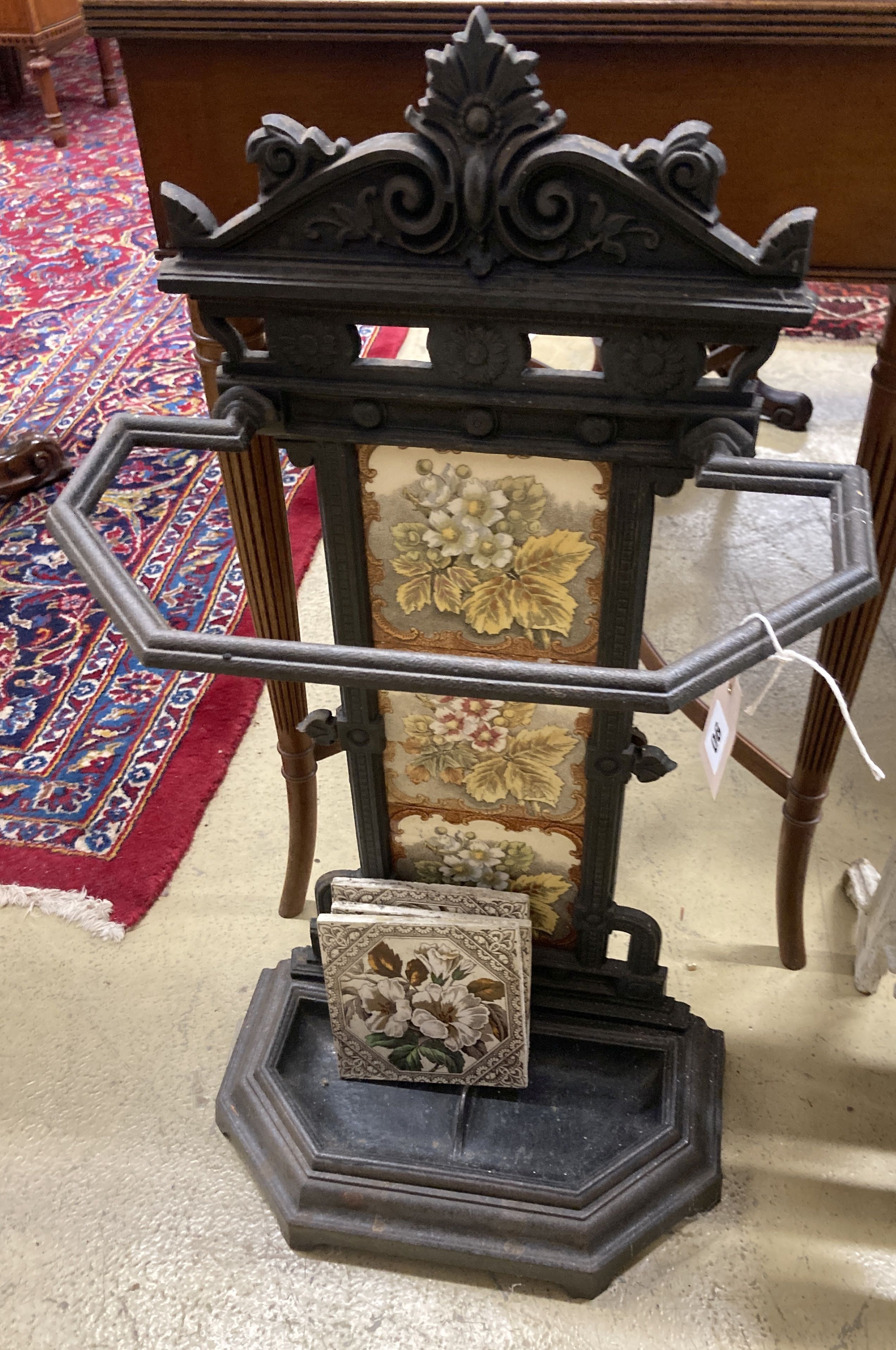 A Victorian style painted cast iron stick stand with tile inset back, width 40cm, depth 21cm, height 78cm